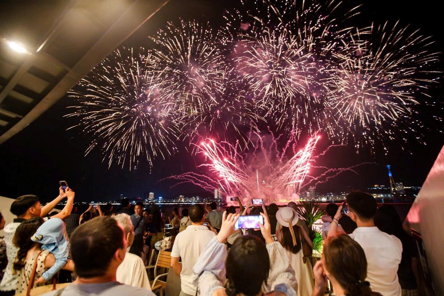 Travelers view fireworks in a Halong Bay dinner cruise