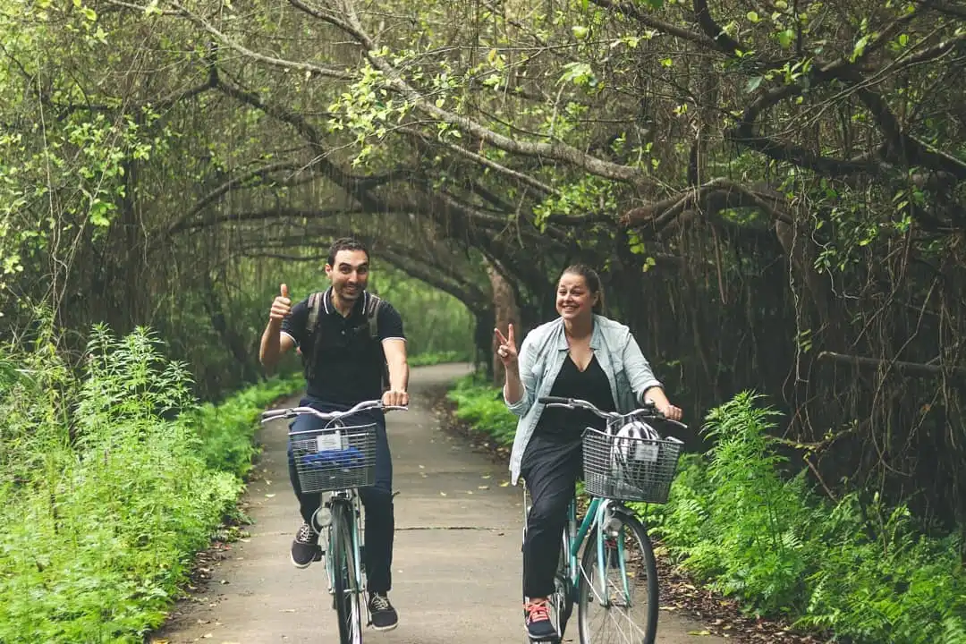 Travelers riding bike on Viet Hai Island during a 3-day itinerary cruise