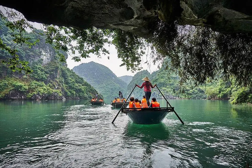 Travelers sailed by local in bamboo boat to visit Luon Cave