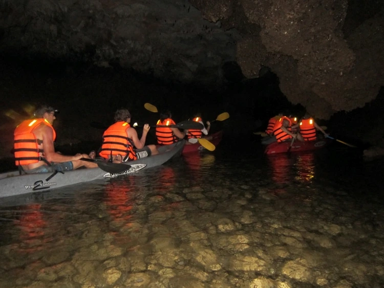 Travelers visit Dark Cave by kayak