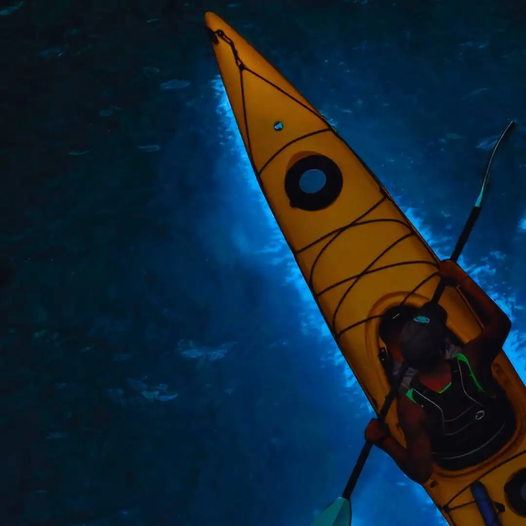 travelers kayaking through the bioluminescence of Lan Ha Bay