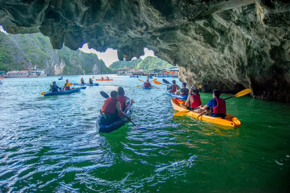 Travelers kayak in Luon Cave, Halong Bay