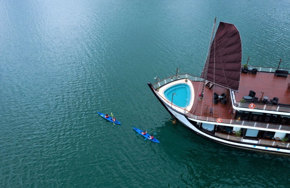 Travelers kayaking in front of Amanda Luxury Cruise