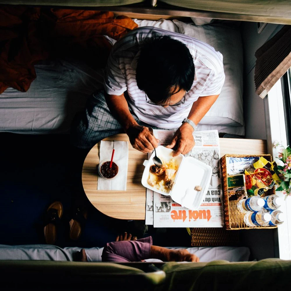 Passenger eating on a train from Hoi An to Halong Bay