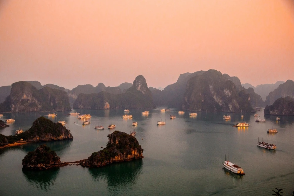 Cruises under sunset in Halong Bay in January