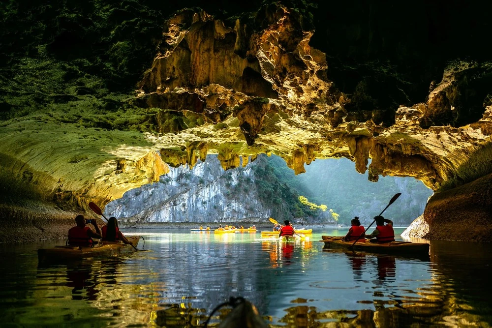 Tourists kayaking through a cave in Halong Bay in September