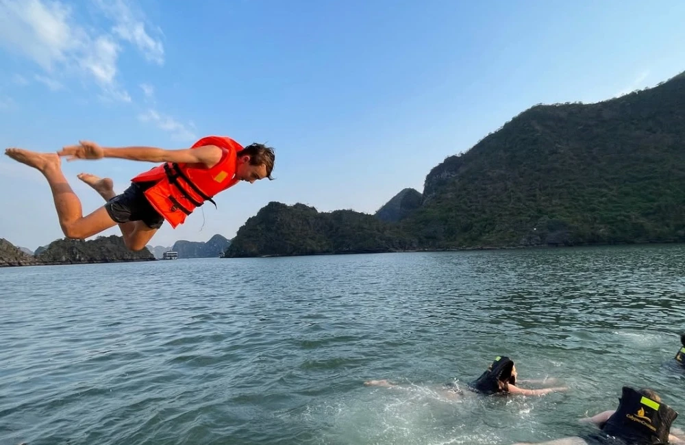 Travelers jumping from the cruise to the water of Halong Bay